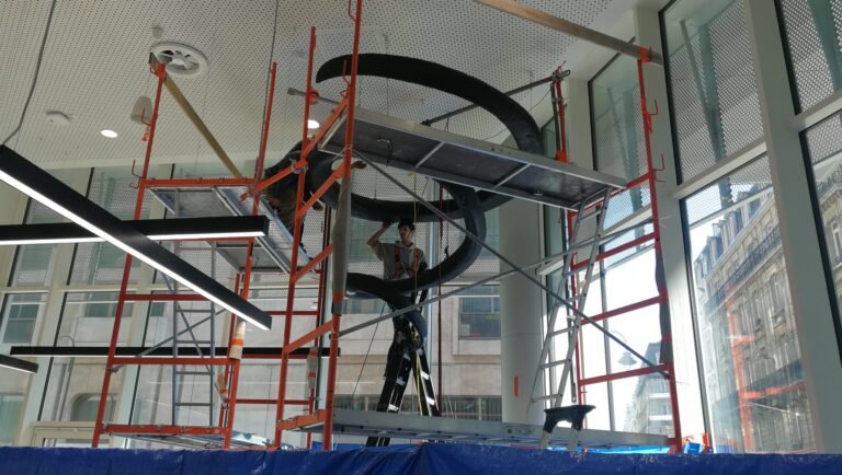 Montage d'une sculpture en spirale sur échafaudage