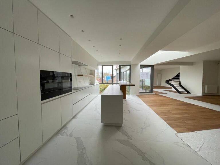 Loft rénové avec cuisine blanche et parquet en chêne