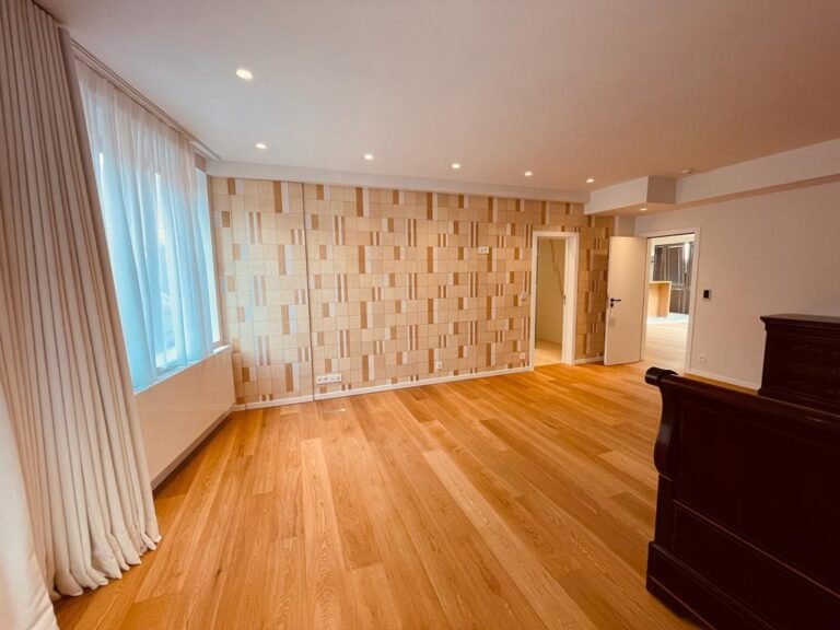 Chambre rénovée avec parquet et papier peint