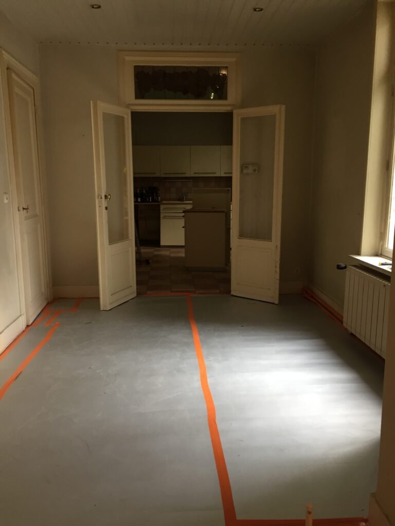 Avant travaux : pièce vidée et protégée, vue vers l'ancienne cuisine